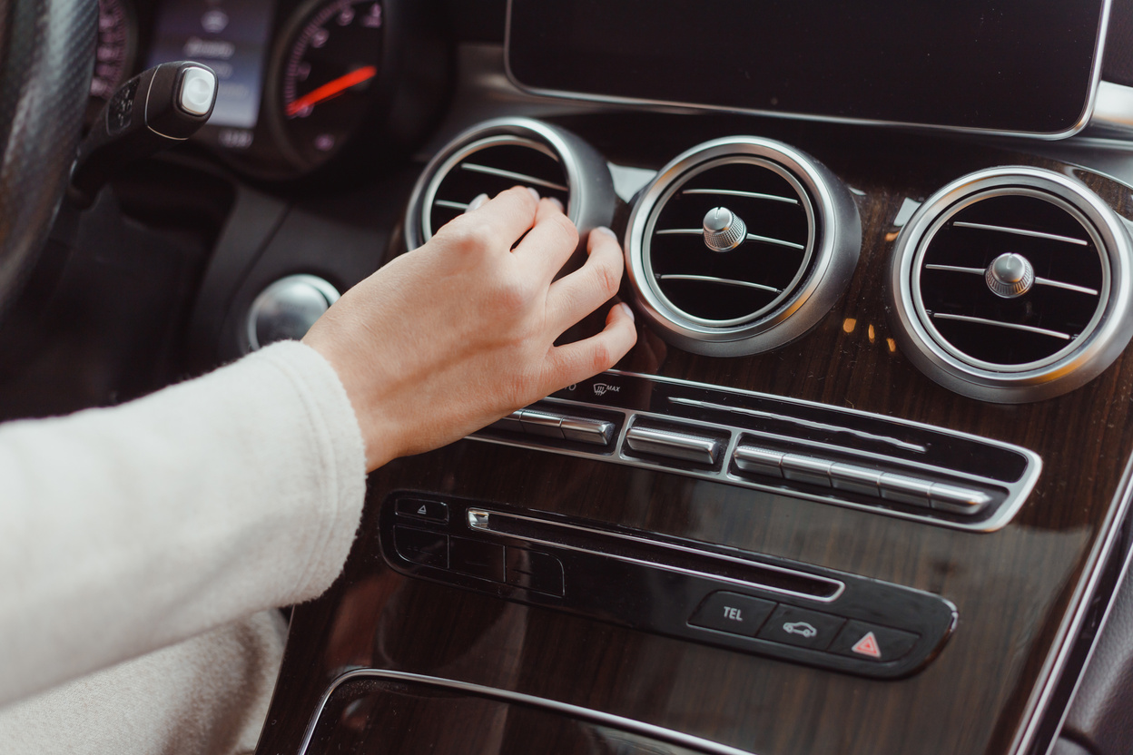 Hand of Woman Turning on Car Air Condition System,Button on Dashboard in Car Panel,Auto Car Air Condition